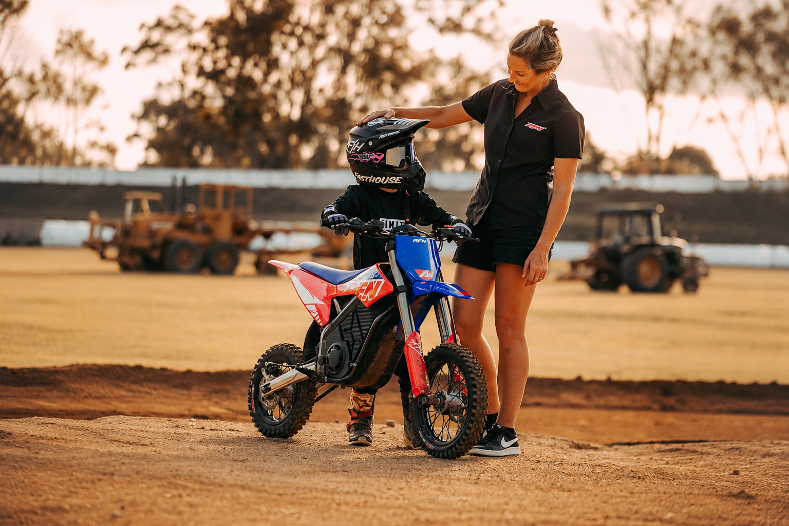 Madre acompañando a su hijo con casco sobre una moto de cross eléctrica RFN Warrior